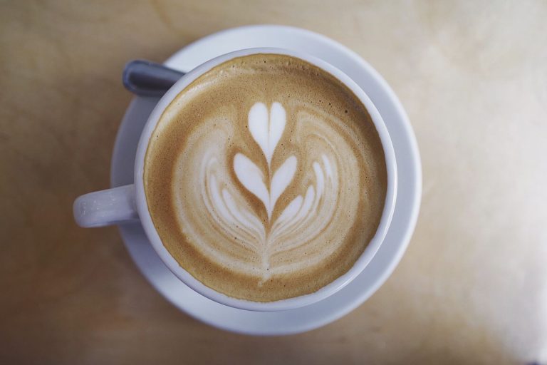 Taza de café con leche con dibujo de latte art en forma de hoja
