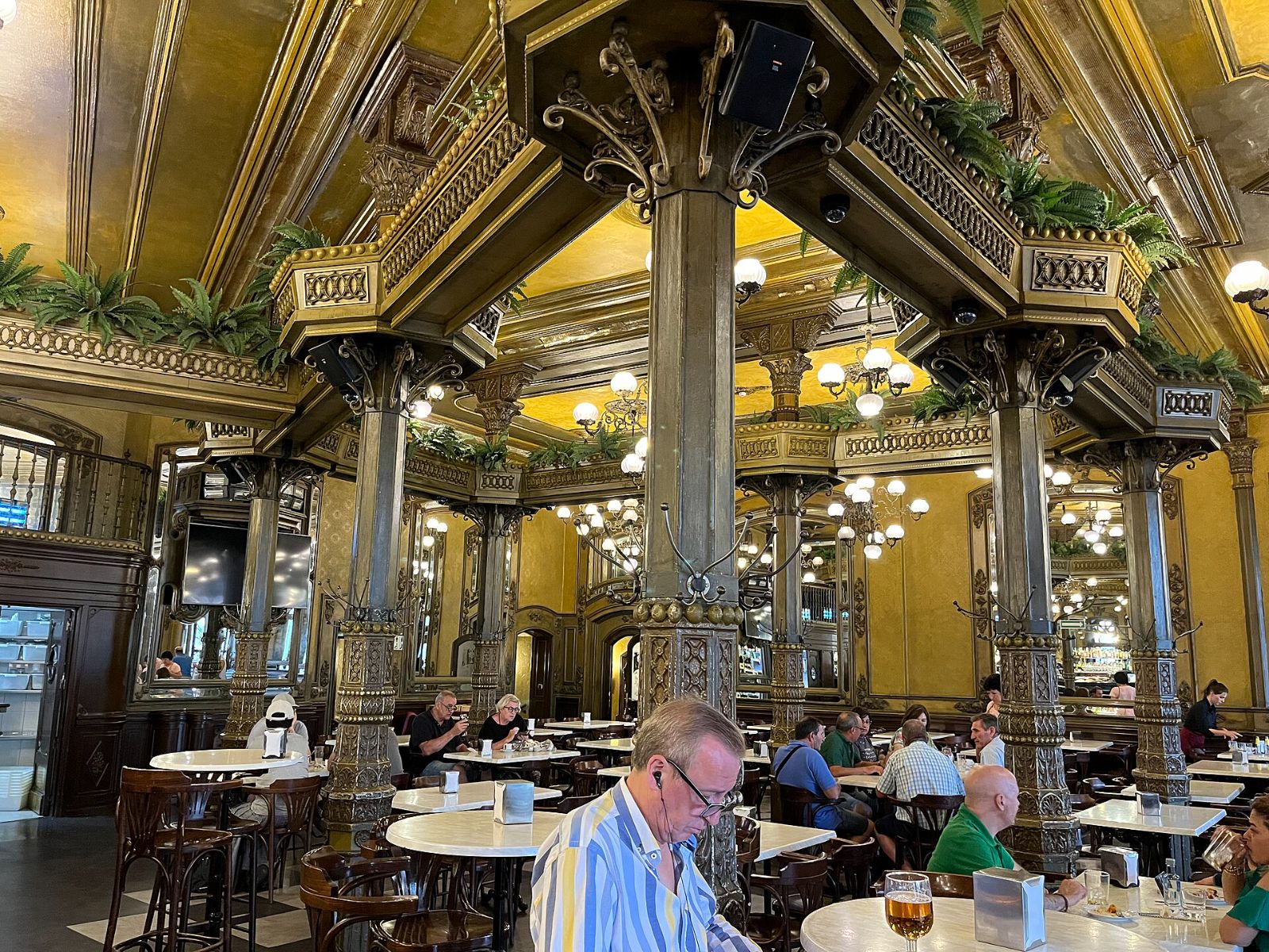 Interior modernista del Café Iruña de Pamplona con sus columnas, lámparas y espejos