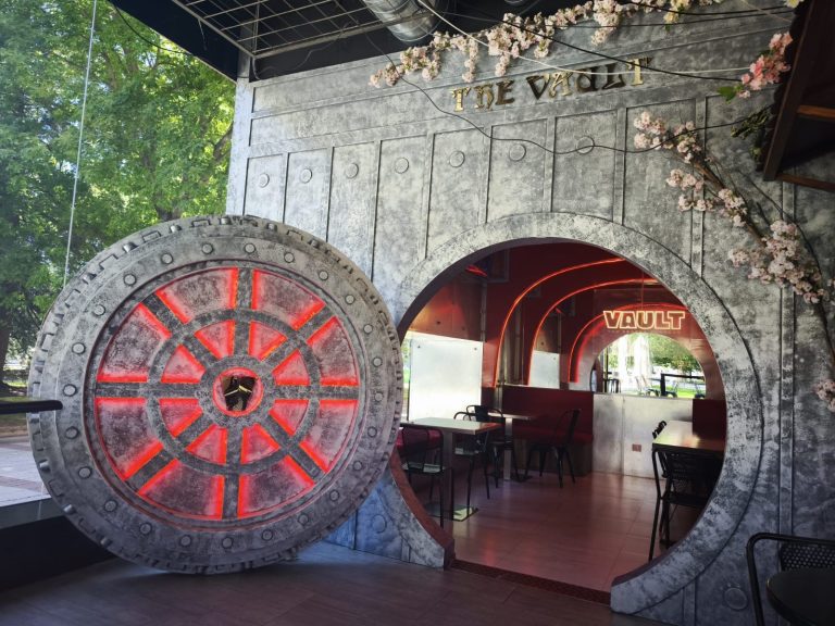 Entrada de Vault Top Secret Burgers, con una puerta circular inspirada en una cámara acorazada