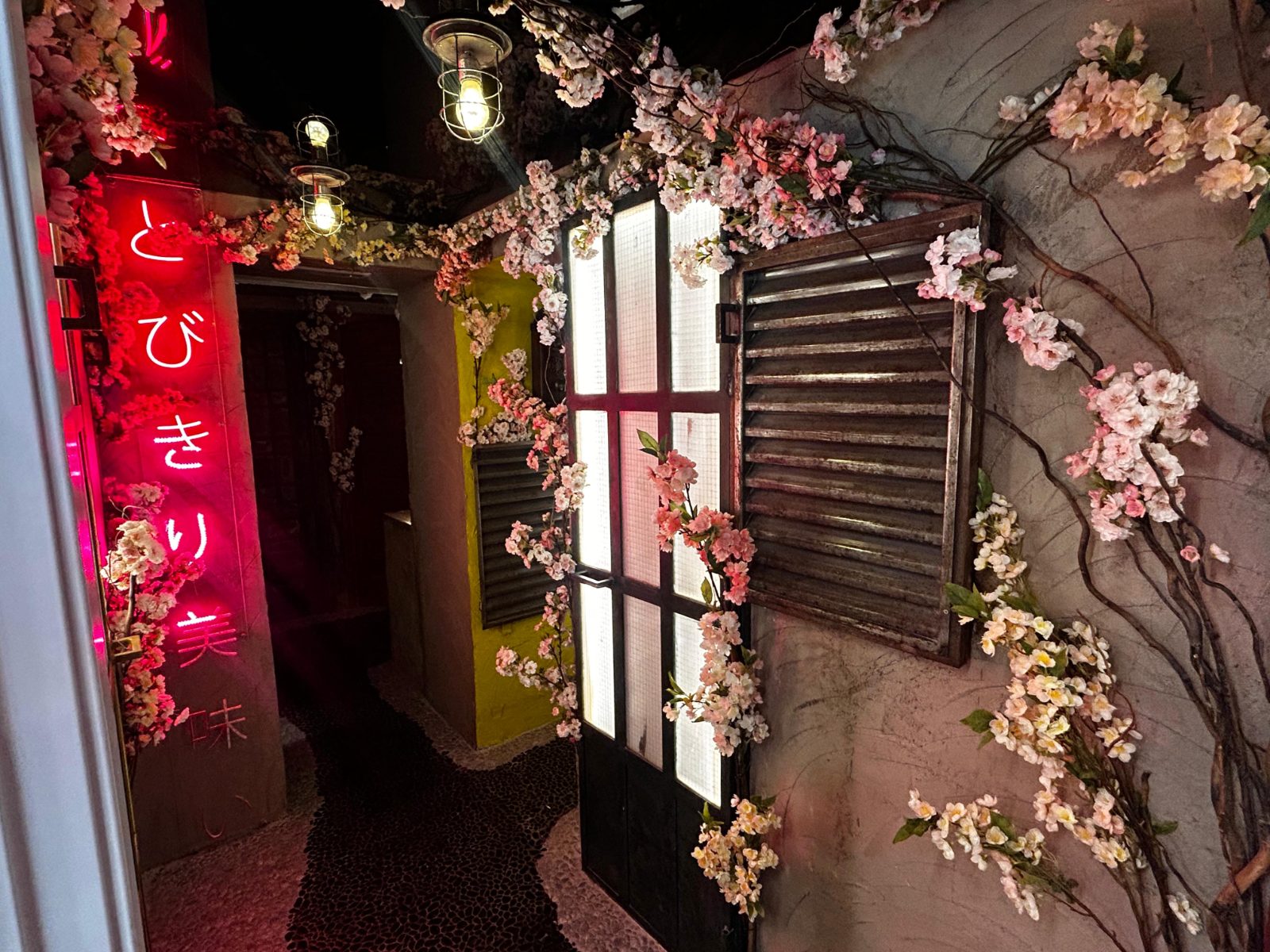 Pasillo de Vault con un letrero de neón en japonés y flores